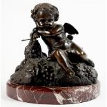 A BRONZE SCULPTURE OF A CHERUB SEATED ON A MOUND WITH GRAPES, MARBLE BASE, 29CM H