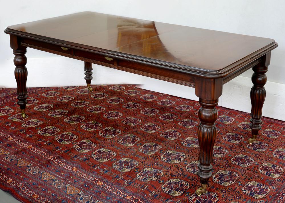 A VICTORIAN STYLE MAHOGANY EXTENDING DINING TABLE ON BRASS CASTORS WITH ONE LEAF, 78CM H; 215 X