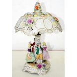 A GERMAN FLORAL ENCRUSTED PORCELAIN LAMP, DECORATED WITH TWO DANCING COUPLES, THE DOMED SHADE