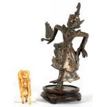 A SOUTH EAST ASIAN SILVERED BRONZE SCULPTURE, 15CM H EXCLUDING WOOD BASE AND AN IVORY NETSUKE OF