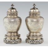 A PAIR OF EDWARD VII CHINOISERIE ENGRAVED SILVER JARS, COVERS AND STANDS IN WILLIAM AND MARY STYLE