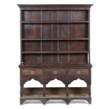 A GEORGE III OAK DRESSER with cavetto cornice to the boarded three shelf rack, the base fitted three