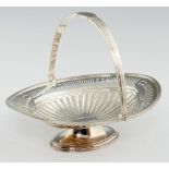 A GEORGE V NEO CLASSICAL STYLE PIERCED SILVER CAKE BASKET with fluted swing handle, 23cm h, by Lee &