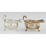 A PAIR OF GEORGE III SILVER SAUCE BOATS with gadrooned rim and leaf capped flying handle, on hoof