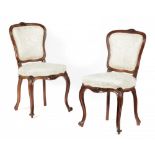 A PAIR OF VICTORIAN CARVED WALNUT SIDE CHAIRS, C1860 with padded cartouche back++One chair with