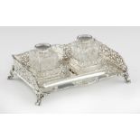 AN EDWARD VII GADROONED SILVER INKSTAND with saw pierced galleries and pair of silver capped cut