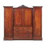 A WILLIAM IV BREAKFRONT PLUM PUDDING MAHOGANY WARDROBE, C1830-40 with carved anthemion crest flanked