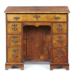 A GEORGE II WALNUT AND FEATHERBANDED KNEEHOLE DESK OR DRESSING TABLE, MID 18TH C the quarter