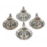 A SET OF FOUR VICTORIAN SILVER CHAMBERSTICKS with fluted sconce and shaped pan, nozzle and