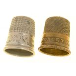 A VICTORIAN STAMPED BRASS THIMBLE, INSCRIBED FORGET ME NOT AND A SLIGHTLY LARGER NICKEL PLATED