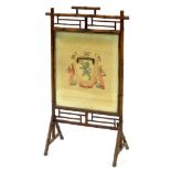 A BAMBOO FIRE SCREEN WITH WOOLWORK ARMORIAL PANEL OF EMMANUEL COLLEGE, 111CM H X 61CM W, EARLY