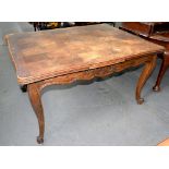 A CARVED OAK DINING TABLE ON SCROLLING LEGS WITH PARQUETRY DRAW LEAF TOP, 75CM H X 100CM W