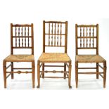 A SET OF THREE ASH SPINDLE BACK RUSH SEATED DINING CHAIRS, EARLY 20TH C