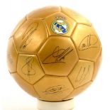 A GOLD COLOURED ORNAMENTAL FOOTBALL, REAL MADRID WITH PRINTED SIGNATURES