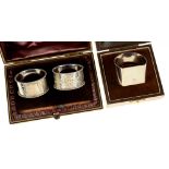A PAIR OF VICTORIAN SILVER NAPKIN RINGS, BIRMINGHAM 1899, CASED AND A GEORGE VI SILVER NAPKIN