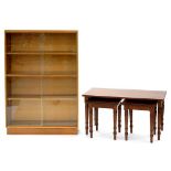 A MAHOGANY NEST OF TABLES ON TURNED LEGS AND A 1970'S BOOKCASE ENCLOSED BY GLASS DOORS, 119CM H;