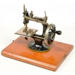 A SINGER MINIATURE SEWING MACHINE , ROLL TOP CASE