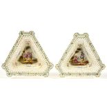 A PAIR OF TRIANGULAR CONTINENTAL CREAM GLAZED EARTHENWARE OPENWORK STANDS, PAINTED WITH LOVERS AND