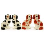 TWO PAIRS OF STAFFORDSHIRE EARTHENWARE SPANIELS, ONE SPONGED IN BLACK, THE OTHER WITH FEATHERY RED