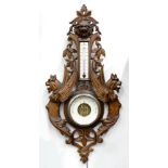 A FRENCH CARVED AND STAINED SOFTWOOD ANEROID BAROMETER, WITH LION MASK AND WINGED GROTESQUES, THE