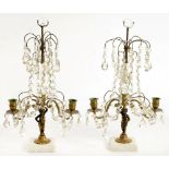 A PAIR OF REGENCY STYLE BRASS CHERUB FIGURAL CANDELABRA HUNG WITH FACETED GLASS DROPS AND