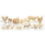 THIRTEEN MINIATURE IVORY CARVINGS OF ANIMALS INCLUDING DOG, CAT, RABBIT, COW, GOAT AND POULTRY,