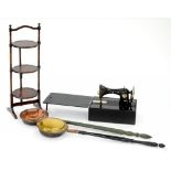 A MAHOGANY THREE TIER CAKE RACK, A TAILOR BIRD SEWING MACHINE AND TWO WARMING PANS