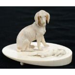 A MINIATURE IVORY CARVING OF A HOUND AND RABBIT ON OVAL BASE, 9CM H, LATE 19TH C