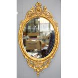 A VICTORIAN OVAL GILTWOOD AND COMPOSITION MIRROR, 89CM H