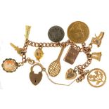 A GOLD CHARM BRACELET, UNMARKED, WITH A SOUTH AFRICAN POND, 1898, FIVE 9CT GOLD CHARMS, AND