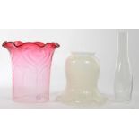 A CRANBERRY SHADED GLASS LAMP SHADE WITH FRILLED RIM AND RIPPLED MOULDING, 21CM H, ANOTHER AND A