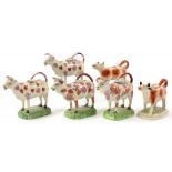 FOUR STAFFORDSHIRE LUSTRE WARE COW CREAMERS AND TWO OTHER STAFFORDSHIRE RED SPONGED COW CREAMERS,