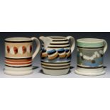 TWO MOCHA WARE MUGS AND A BARREL SHAPED JUG, C1830 one of the mugs with multichambered  slip pot