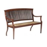 AN ENGLISH ARTS & CRAFTS TEAK SETTEE, C1900  with curved, slatted back, drop in caned seat, 96cm