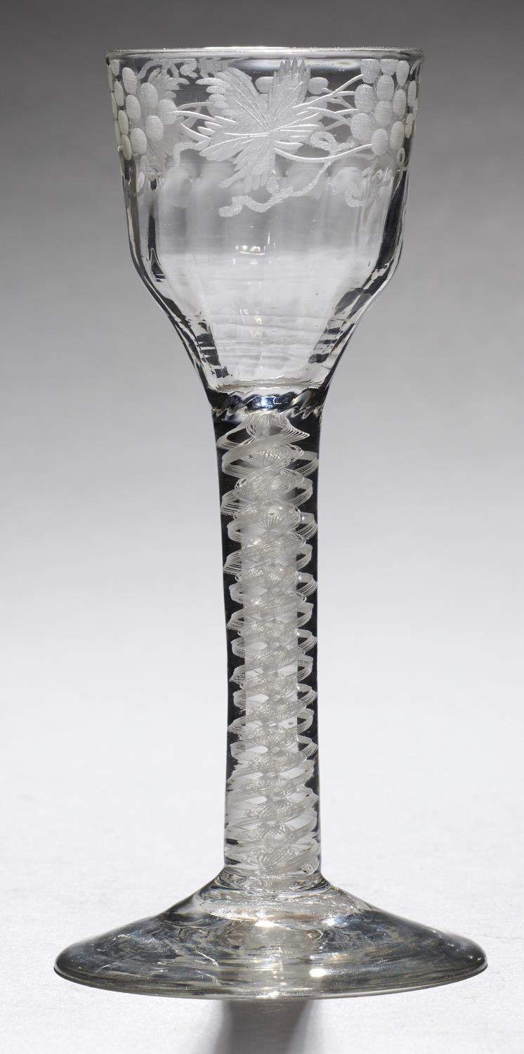 AN ENGLISH WINE GLASS, C1770  the fluted ogee bowl engraved with grapevines, on double series opaque
