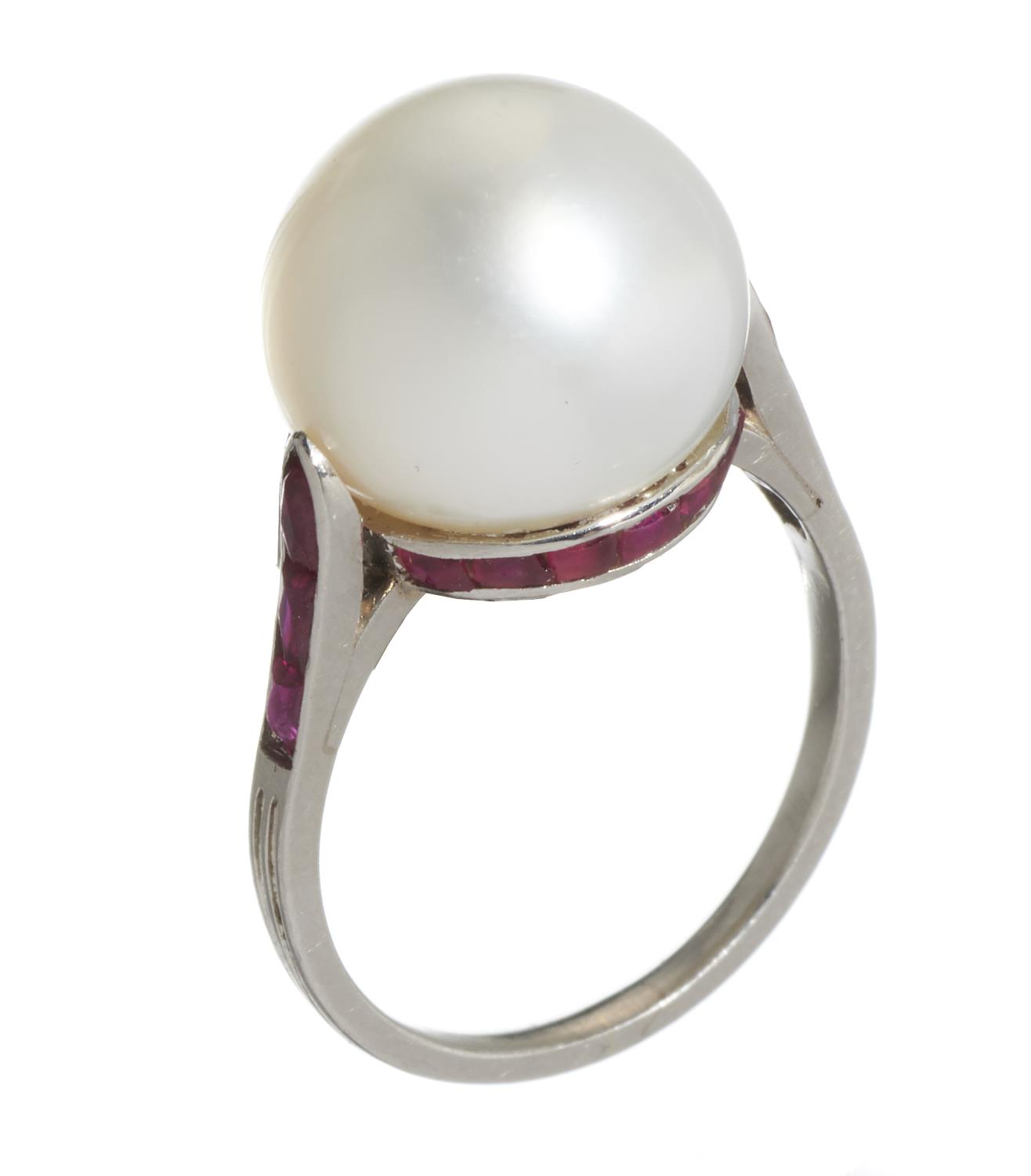 A RUBY AND CULTURED PEARL RING  the 1.1cm cultured pearl set in a girdle of calibre cut rubies