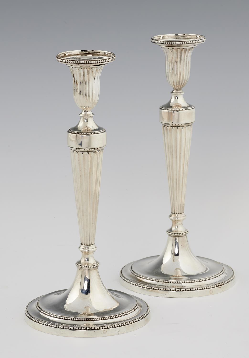 A PAIR OF GEORGE III NEO CLASSICAL SILVER CANDLESTICKS  of fluted and beaded design, crested (on