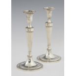 A PAIR OF GEORGE III NEO CLASSICAL SILVER CANDLESTICKS  of fluted and beaded design, crested (on