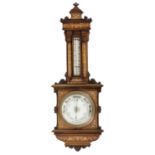 A VICTORIAN CARVED MAHOGANY AND ROSEWOOD ANEROID BAROMETER, C1890  in architectural style, inlaid in