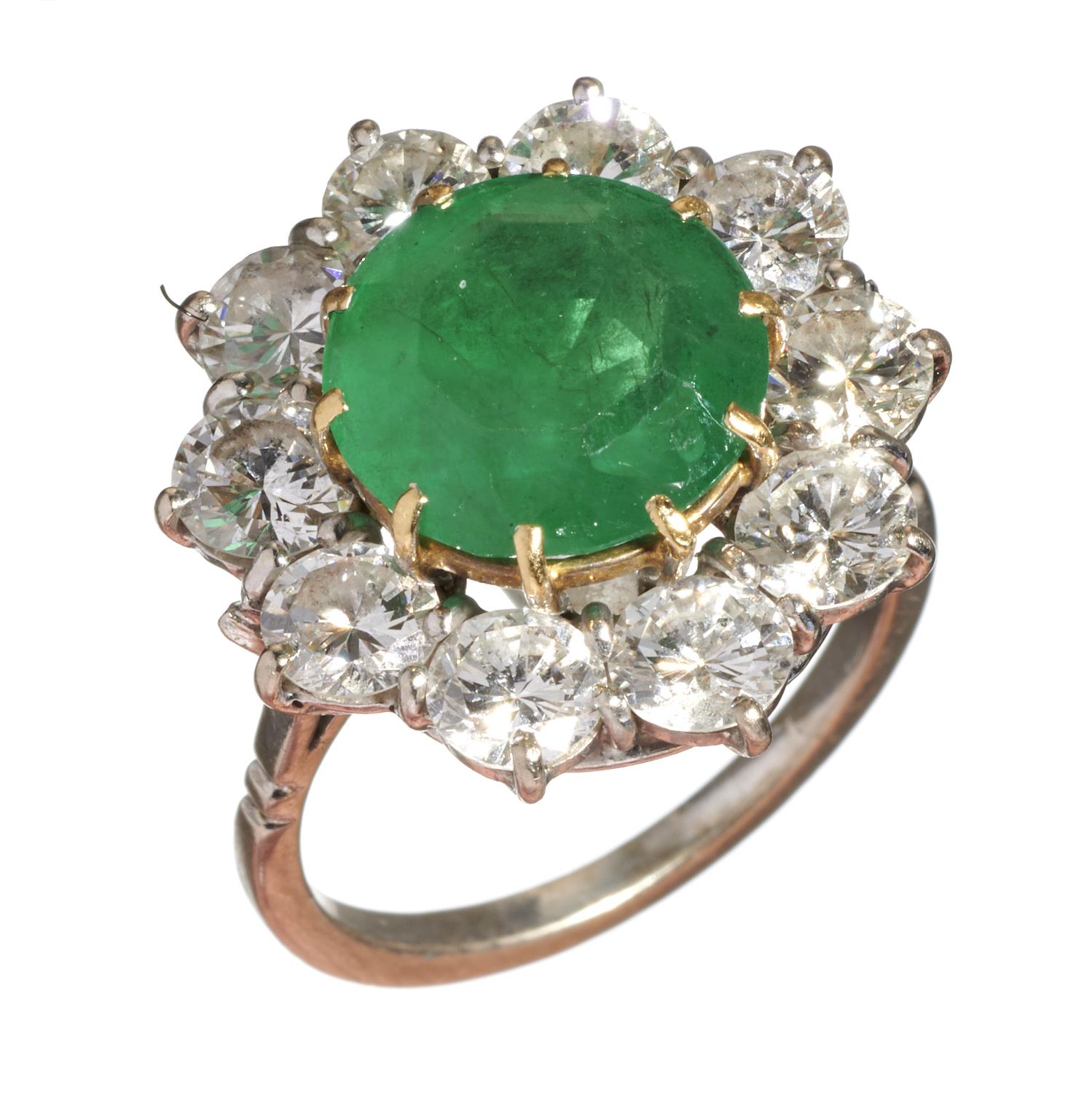 AN EMERALD AND DIAMOND CLUSTER RING  the emerald  in a surround of ten round brilliant cut diamonds,