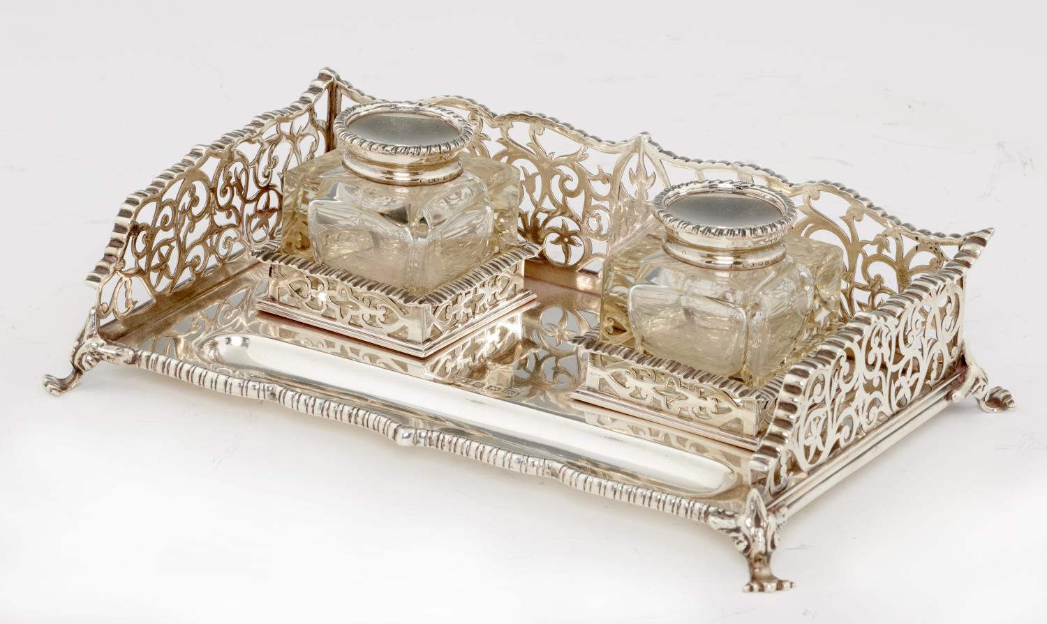 A GEORGE V SILVER INKSTAND  with saw pierced gallery and pair of silver mounted glass wells, 26cm l,