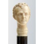 LORD BYRON INTEREST.  AN EBONY CANE WITH CARVED IVORY POMMEL, 19TH C  the pommel in the form of