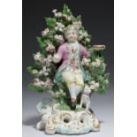 A DERBY CANDLESTICK FIGURE OF A SEATED BOY, C1770  with a hound at his feet before bocage, on