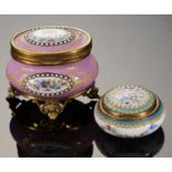 AN OVAL PALAIS ROYAL GILTMETAL MOUNTED PINK ENAMEL BOMBE JEWEL CASKET AND AN ENAMELLED COMPACT, LATE