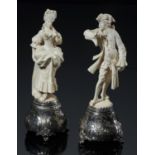 A PAIR OF GERMAN SILVER MOUNTED IVORY STATUETTES OF A LADY AND GALLANT,  c1900 the bombe base chased