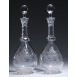 A PAIR OF ENGRAVED AND CUT GLASS DECANTERS AND STOPPERS, EARLY 20TH C  with faceted neck and