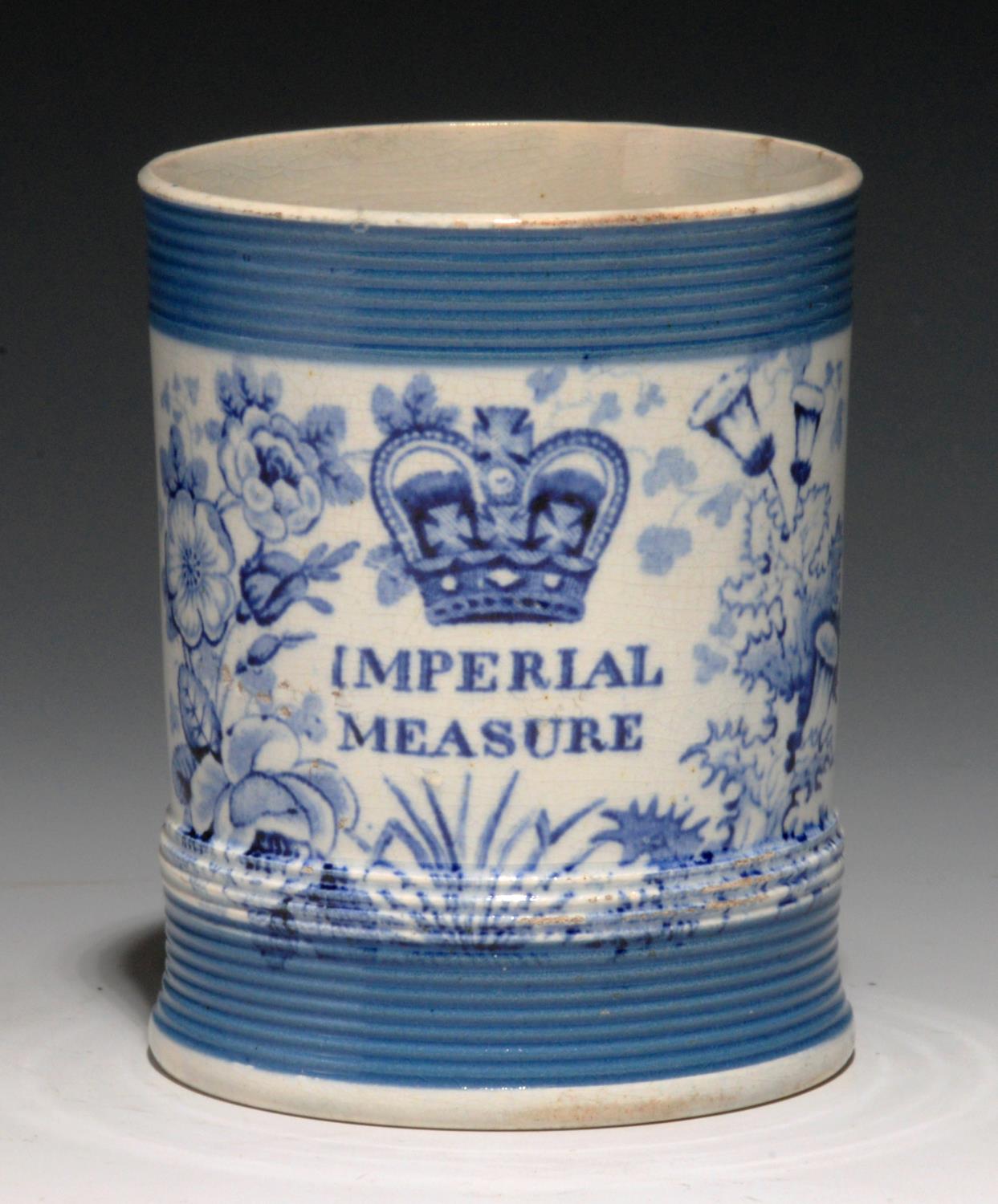 A BLUE PRINTED EARTHENWARE IMPERIAL MEASURE, C1840  half pint, with reeded blue bands, 9cm h Good