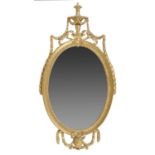 A REGENCY OVAL GILTWOOD AND COMPOSITION MIRROR, EARLY 19TH C  hung with husks, 103cm h, 53cm w Old