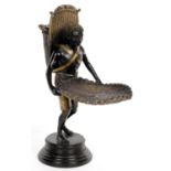 A BLACK AND BRONZED STATUETTE OF A NEGRO MAN CARRYING A WICKER TRAY AND POD, 35CM H