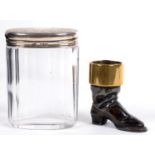 A VICTORIAN BRASS MOUNTED LEAD BOOT NOVELTY MATCH STAND, 6CM H AND A GLASS JAR WITH SILVER COVER